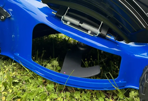 Homme en salopette bleue réparant la lame d'une tondeuse à gazon sur l'herbe à Vierzon dans le Cher 18